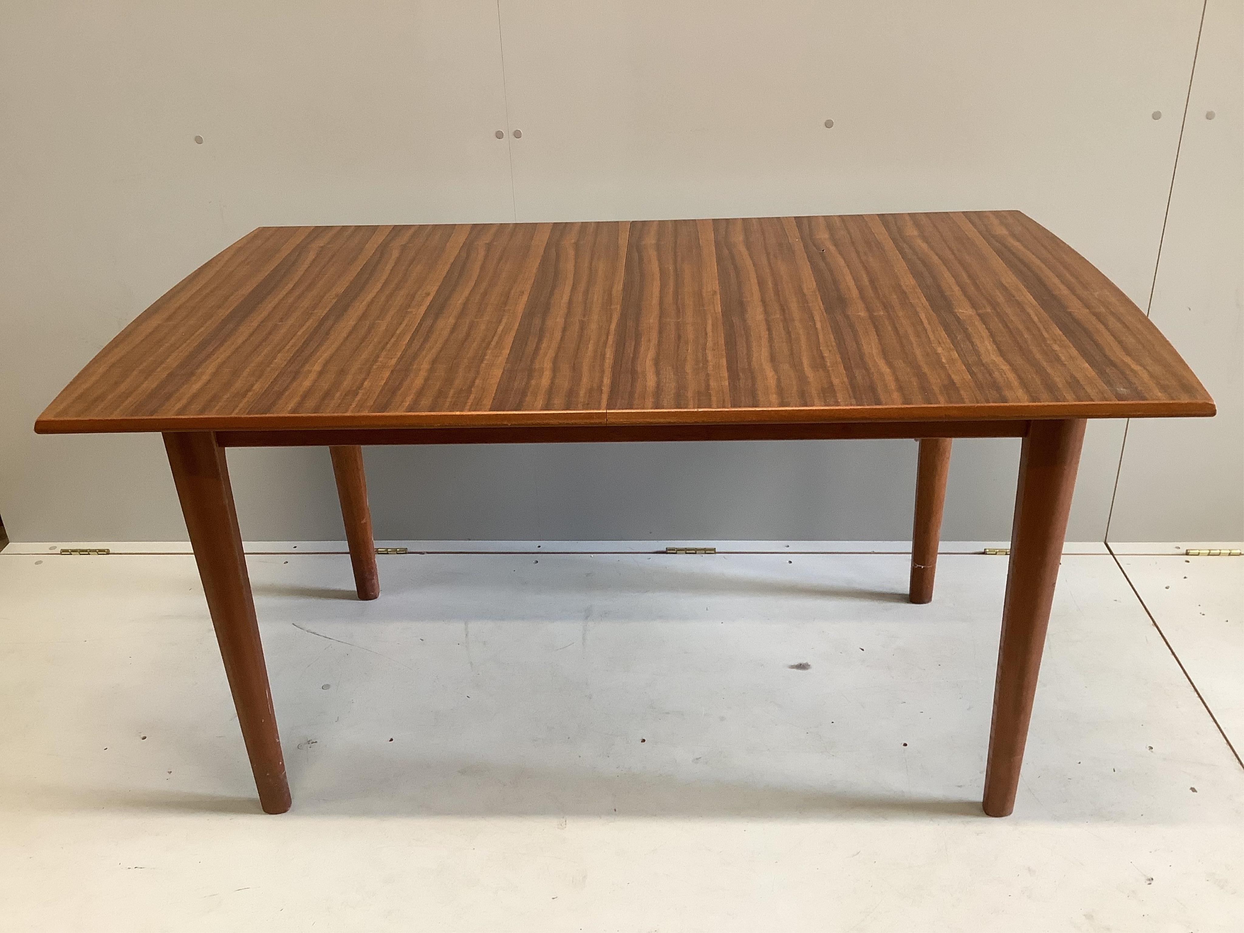 A mid century Gordon Russell teak dining suite comprising rectangular extending table, twelve chairs and a sideboard, width 140cm, depth 80cm, height 74cm. Condition - fair, with the leaf in it's an eight seater